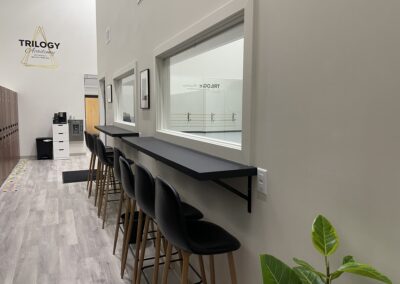 Black chairs with black desks attached, positioned near the window of Trilogy Dance Academy